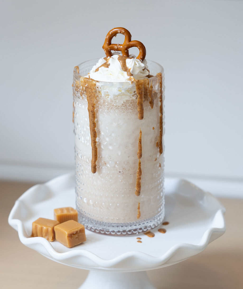 Salted caramel pretzel protein shake topped with whipped cream and a pretzel